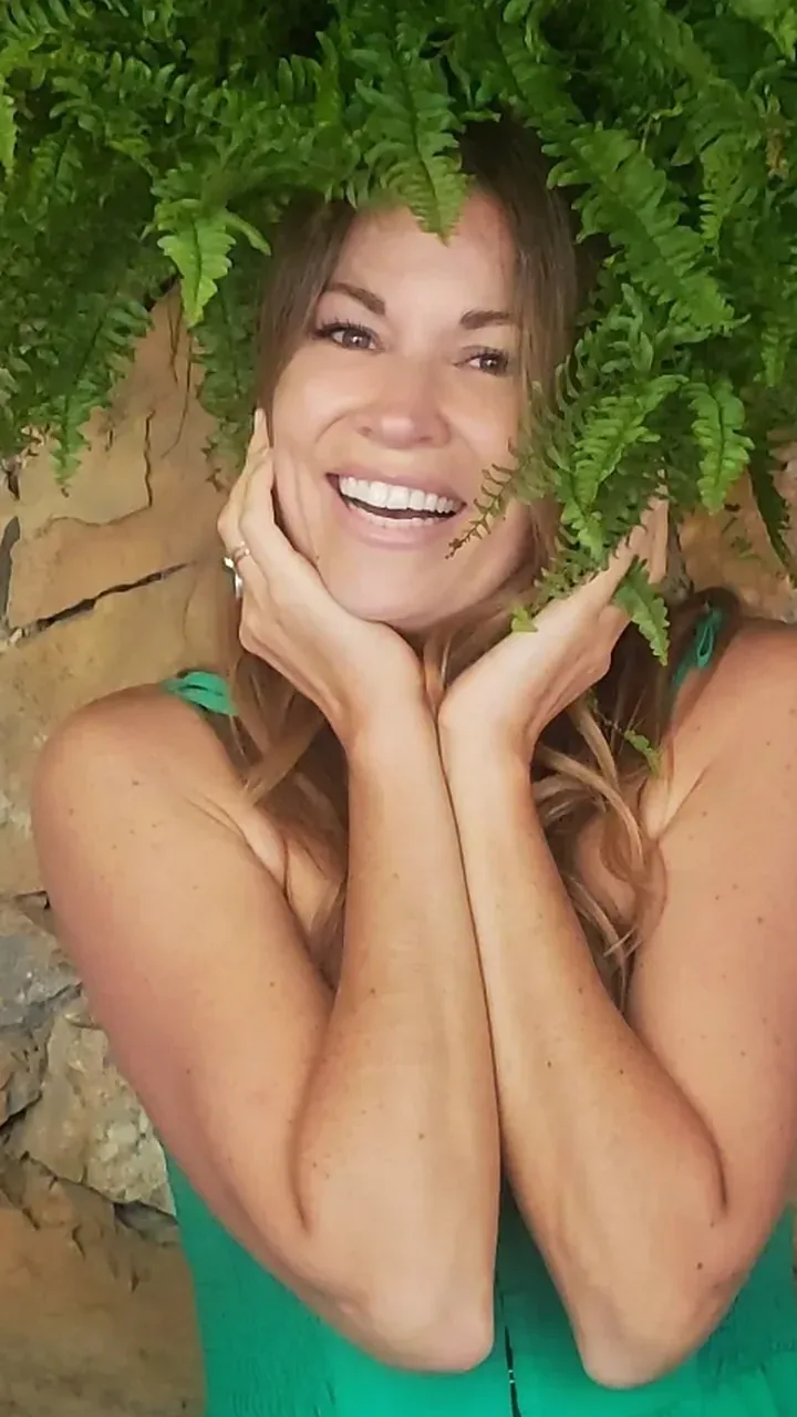 Rayne laughing under a fern