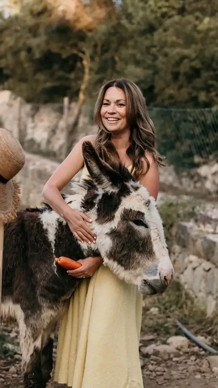 Rayne with a donkey, holding a carrot
